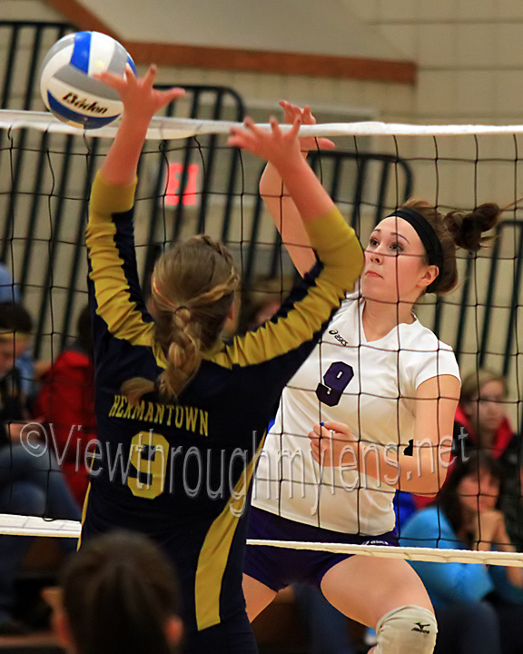 Emily Fossen makes a kill past Hermantown's Carmen Bergstedt