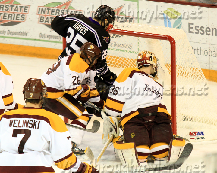 Mankato’s Eriah Hayes makes sure a puck that squirted under Matt McNeely was in the net for a goal.