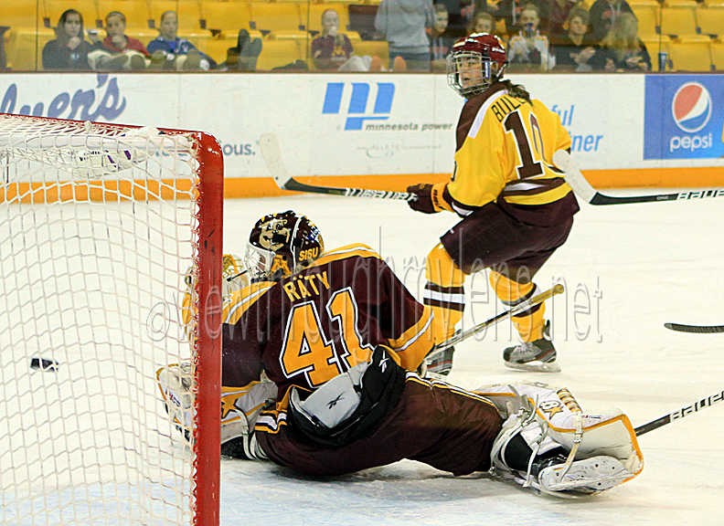 Audrey Cournoyer watches her backhand enter the net behind Noora Raty